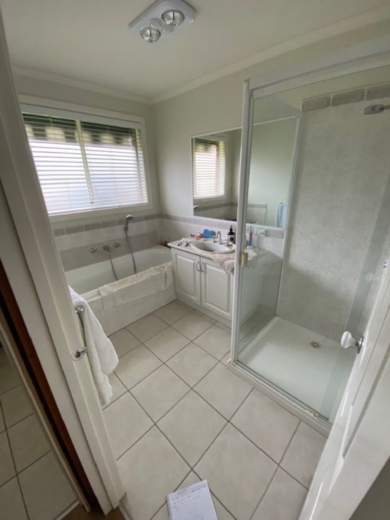Panorama Avenue bathroom before renovation, dated wall and floor tiling with a framed shower screen
