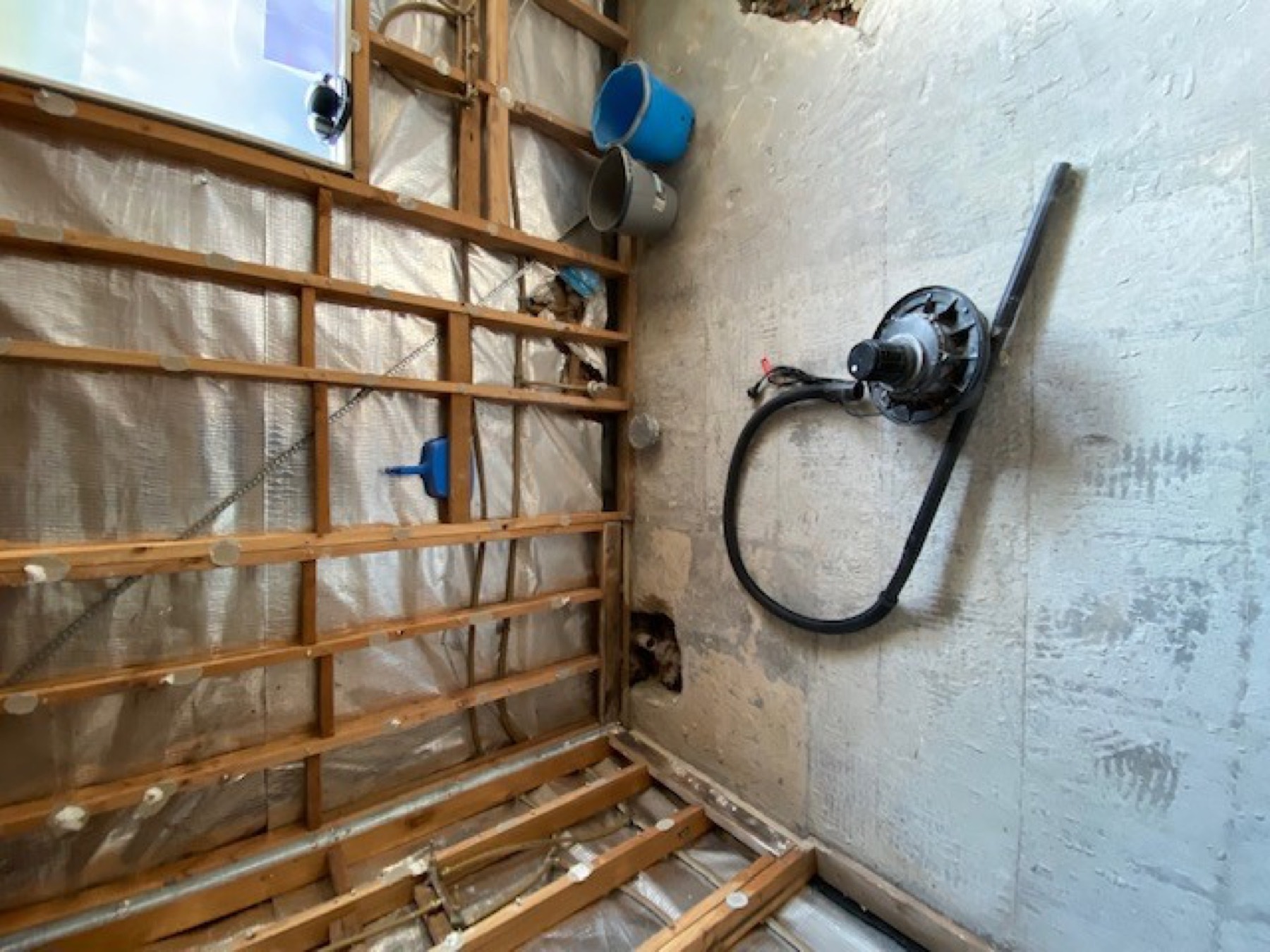 Panorama Avenue bathroom during renovation, stripped to studs with waterproof membrane and plumbing rough-in